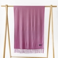 Dusty pink cashmere blend scarf with elegant tassels hanging on a wooden display - Dusky Pink