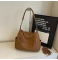 Detailed macro view of brown pebbled leather tote bag with silver zippers and side pockets - Brown