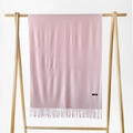 Solid soft pink cashmere scarf with tassels hanging on a minimalist wooden frame stand - Baby Pink