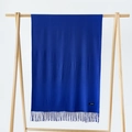 Royal blue cashmere scarf with fringe hanging on a wooden hanger against a gray background - Sapphire Blue