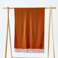 Solid dark orange cashmere scarf for women with elegant tassels on a wooden hanger - Caramel