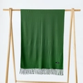 Dark green cashmere scarf with fringe details hanging on a minimalist wooden hanger - Verdant
