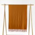 Minimalistischer einfarbiger Schal in Ingwer-Orange mit Fransen auf einem Holzbügel - Hellorange