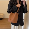 Borsa a secchiello marrone in pelle martellata con dettagli in metallo dorato - Cuoio