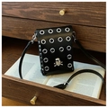 Detail of black crossbody phone bag with silver grommets and rhinestone skull emblem - Skull Style / Black
