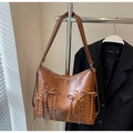 Detail of vintage brown tote bag with woven straps, metallic rivets, and decorative bow - Brown