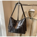 Detail view of dark brown vintage shoulder bag with bow accents and woven leather textures - Black