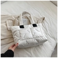 Detail of white quilted puffer tote bag featuring black leather patches and nylon texture - White