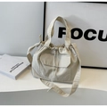 Détail du sac seau en toile crème minimaliste avec cordon et poche avant à rabat - Blanc Cassé