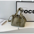 Détail macro du sac seau en nylon vert herbe avec cordons et boucles métalliques - Vert