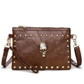 Close-up of vintage brown leather bag with golden skull and square stud details - Dark Brown