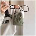 Détail du mini sac seau vert avec cordon montrant la texture durable en nylon ripstop - Vert