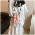 Petit sac bandoulière rose à cordon avec fine sangle noire porté par un modèle - Rose