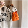 Close-up of bright orange nylon drawstring mini bag with adjustable black strap - Orange Red