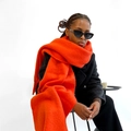 Gros plan détaillé sur l'écharpe orange en mohair avec texture tricotée et franges - Rouge
