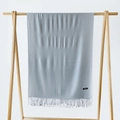 Close-up of a light blue cashmere scarf showing fringe and black label on a wooden rack - Silver Grey / 215*70cm