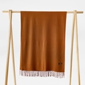 Detail of caramel cashmere scarf with fringes hanging on a wooden hanger on white background - Light Coffee / 215*70cm
