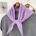 Dettaglio di una sciarpa in maglia viola con morbida trama felpata su gruccia di legno - Viola