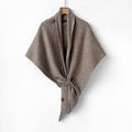 Close-up of the premium wool knit texture and brand label on a brown scarf shawl - Brown