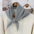 Detailed close-up of a grey knitted triangle scarf with soft cashmere-like texture and weave - Gray