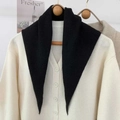 Dettaglio di una sciarpa triangolare in maglia nera su gruccia con cardigan bianco - Nero