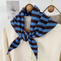 Detailed view of a soft knit striped triangle shawl scarf tied over a cream cardigan - 95*33cm / Blue (ZJP035)
