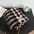 Close-up of black and white plaid cashmere scarf with tassel fringe and brand label - White Coffee