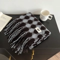 Detail of grey plaid cashmere-feel scarf with fringes and white woven brand label - Blue Coffee