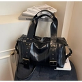 Close-up of black glossy leather bag showing metal eyelet strap and vintage buckles - One Size / Black