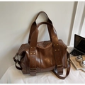 Macro detail of dark brown retro tote bag with golden rivets and polished oil leather texture - One Size / Brown