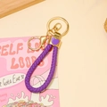 Détail d'un porte-clés en cuir violet avec fermoir doré et petit pendentif cœur - Violet