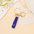 Dettaglio portachiavi in pelle blu reale con strass, anello dorato e chiusura a moschettone - Strass Blu Reale