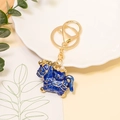 Detailed view of lucky horse keychain with blue enamel, gold edges, and faux pearls - Metal Pendants / Blue