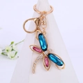 Gold dragonfly keychain featuring large blue and pink crystals and a lobster clasp - Teal