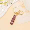 Dettaglio portachiavi in pelle glitter viola con moschettone e anello in metallo dorato - Glitter Viola