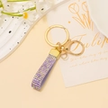 Gros plan sur le porte-clés en cuir strass violet avec anneau et crochet en métal doré - Strass Violet