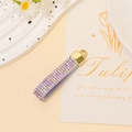 Detail of purple rhinestone tassel keychain with golden metal ring and leather texture - Magic Purple