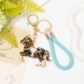 Dettaglio portachiavi a forma di cavallo nero con cristalli e cinturino in pelle blu intrecciata - Nero Con Corda in Pelle