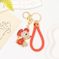 Dettaglio portachiavi topo con strass rossi, cinturino in pelle intrecciata e ciondolo Fu - Topo Rosso con Corda in Pelle Rossa