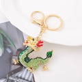 Dettaglio ravvicinato del portachiavi a drago cinese dorato con strass verdi e smalto - Dragone Dorato con Strass Verdi