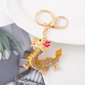 Dettaglio del portachiavi a forma di drago dorato con strass gialli e finiture in smalto - Dragone Dorato con Strass Gialli
