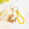 Detail of a golden dragon keychain with amber rhinestones and a braided leather strap - Yellow Rhinestone Dragon With Yellow Rope