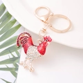 Gros plan d'un porte-clés coq avec strass rouges et blancs et quincaillerie dorée - Style Coq Rouge (颜色2)