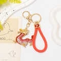 Detailed shot of a red rhinestone dragon keychain with a braided leather lucky cord - Red Rhinestone Dragon With Red Rope B