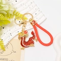 Detail of red rhinestone dragon keychain with woven leather strap and fortune charm - Red Rhinestone Dragon With Red Rope