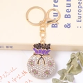 Détail du porte-clés sac de chance avec cristaux multicolores et finition métal doré - Style Strass Mauve