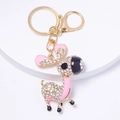 Close-up of golden donkey keychain with sparkling rhinestones and pink enamel details - Pink Style