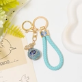 Detail of light blue rhinestone lucky bag keychain with woven leather strap and gold ring - Light Blue Lucky Bag with Leather Rope