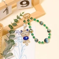 Colgante de gato de la suerte con gema azul y cristales verdes en cadena dorada - Azul