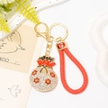 Macro del cinturino in pelle intrecciata rossa e ciondolo portachiavi a borsa con strass - Rosso con Cinturino in Pelle Sintetica